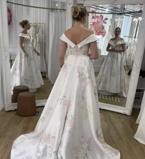 O reflexo perturbador de um vestido de noiva está sendo comp