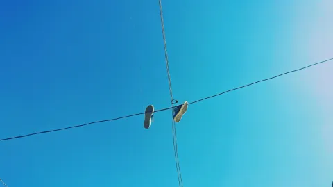 Por que alguns fios de energia têm sapatos pendurados?